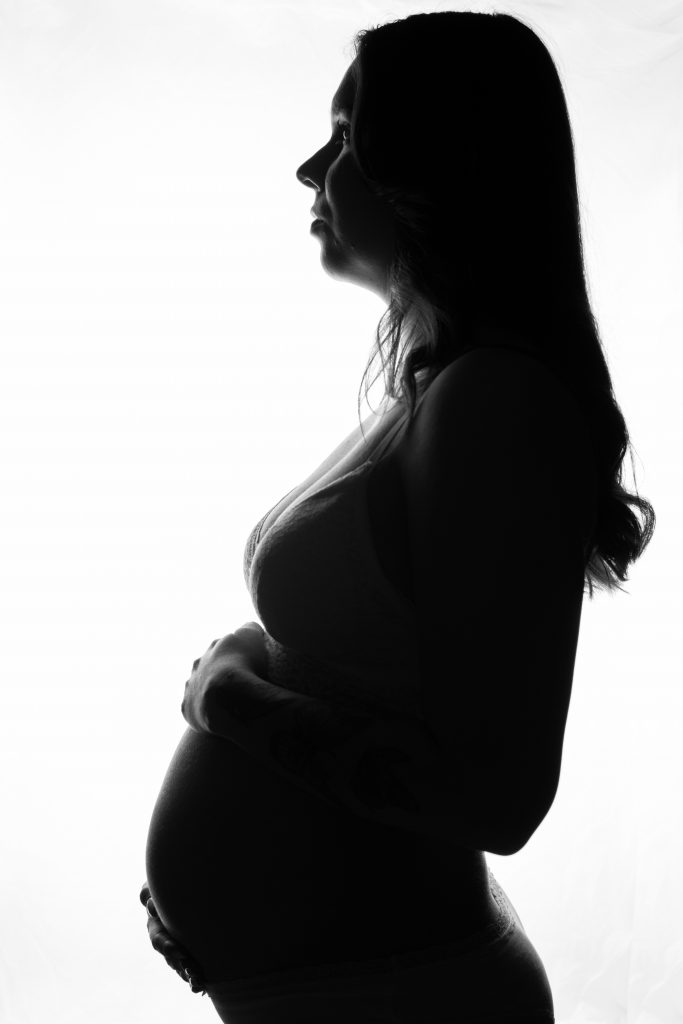 Gegenlichtaufnahme einer schwangeren Frau in der Shilouette